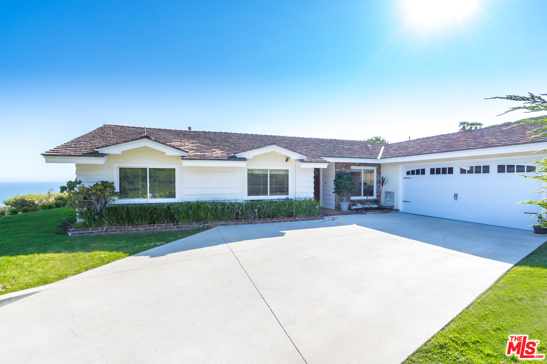 6267 Tapia Drive Malibu, CA 90265 - Photo 2 of 16 a front view of a house with a yard and garage