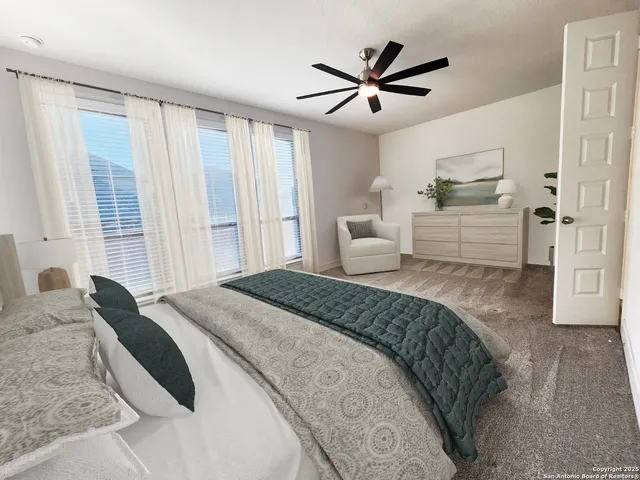 a spacious bedroom with a large bed and a chandelier