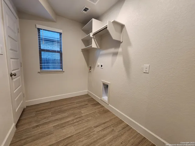 an empty room with wooden floor and cabinet