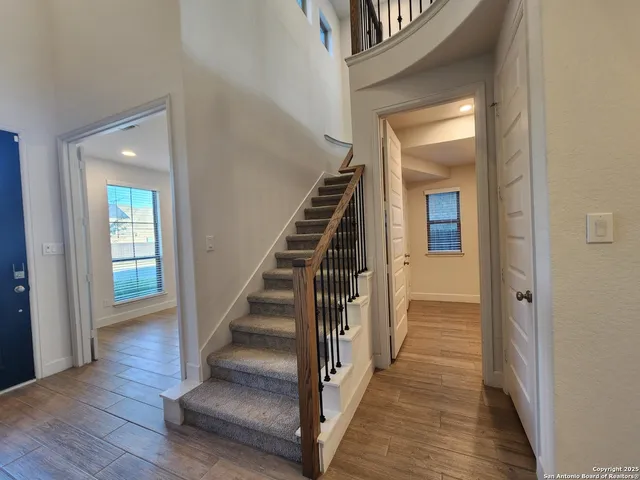 a view of a hallway with wooden floor and entryway