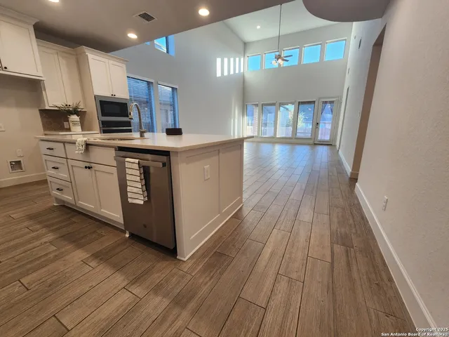 a kitchen with stainless steel appliances granite countertop a stove a sink and a microwave