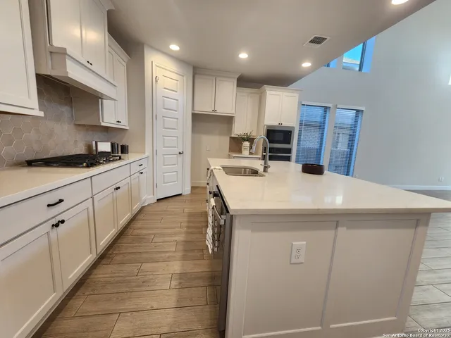 a kitchen with kitchen island a sink a stove and refrigerator