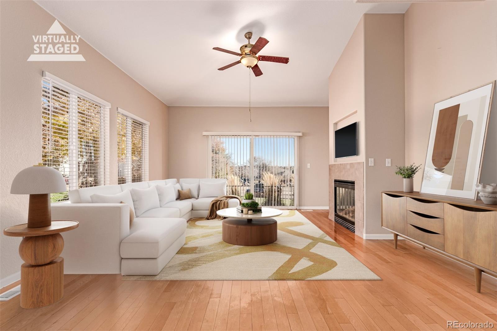 a living room with fireplace furniture and a large window
