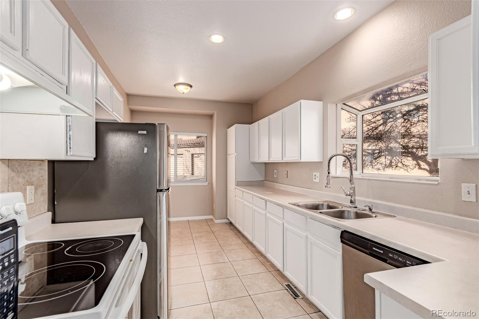 4538 South Atchison Way Aurora, CO 80015 - Photo 18 of 50 a kitchen with a sink stove top oven and refrigerator