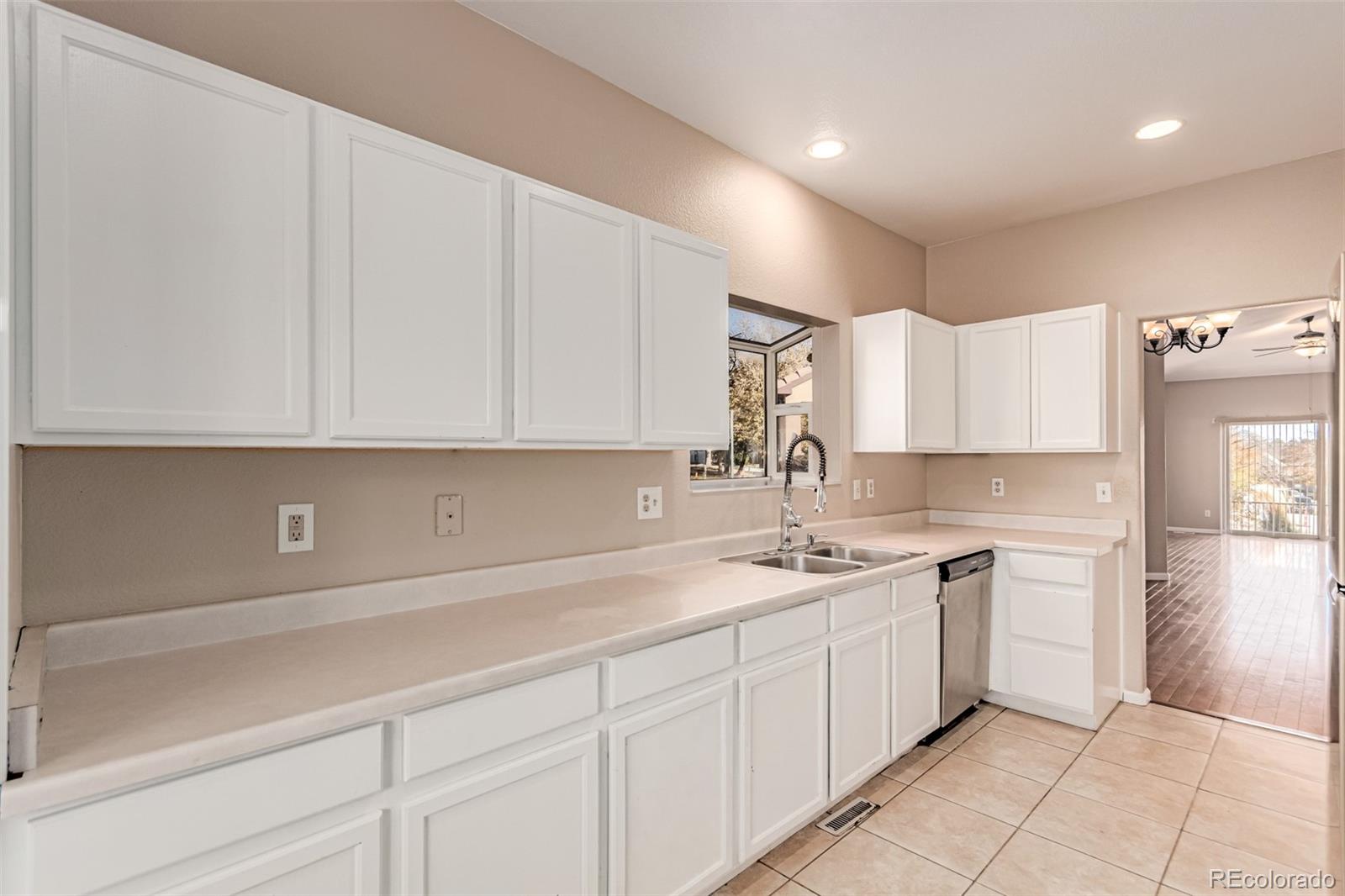 4538 South Atchison Way Aurora, CO 80015 - Photo 19 of 50 a kitchen with a sink dishwasher and white cabinets