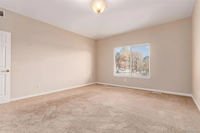 an empty room with window and painted walls