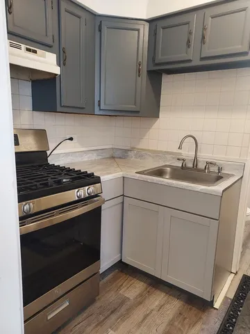 a kitchen with stainless steel appliances granite countertop a sink stove and cabinets
