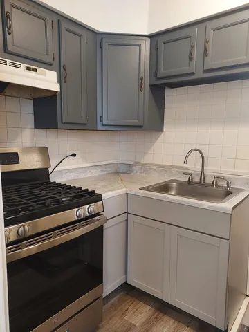 a kitchen with granite countertop white cabinets and stainless steel appliances