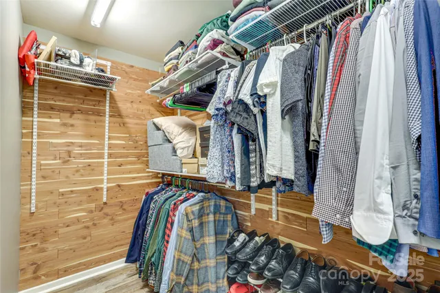 a view of walk in closet with clothes and shoes