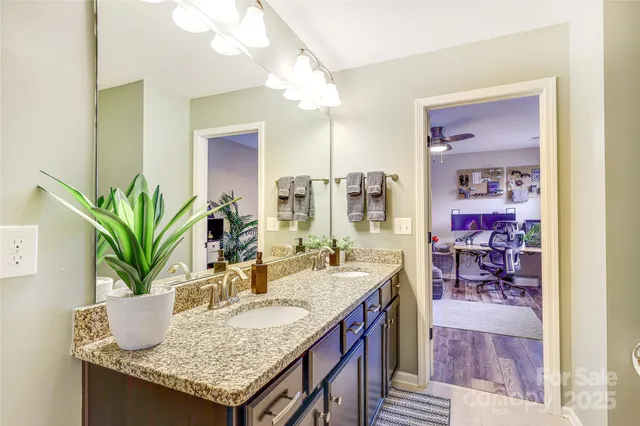 a bathroom with a granite countertop sink and a mirror