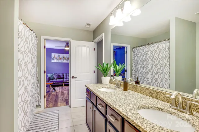 a bathroom with a granite countertop sink a large mirror and a shower