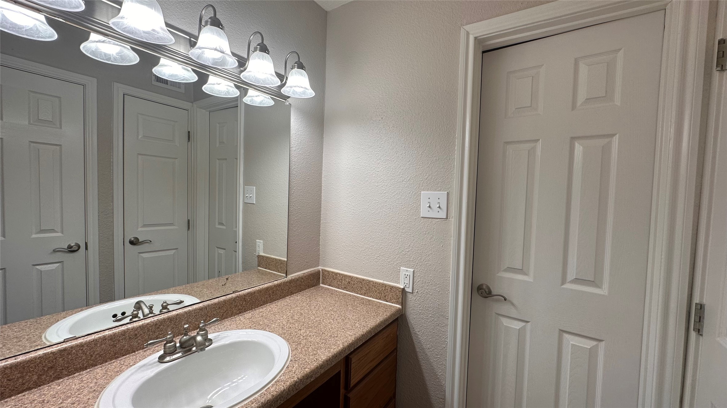 7315 Brompton Street, Unit 303B Houston, TX 77025 - Photo 12 of 14 a bathroom with a granite countertop sink and a mirror