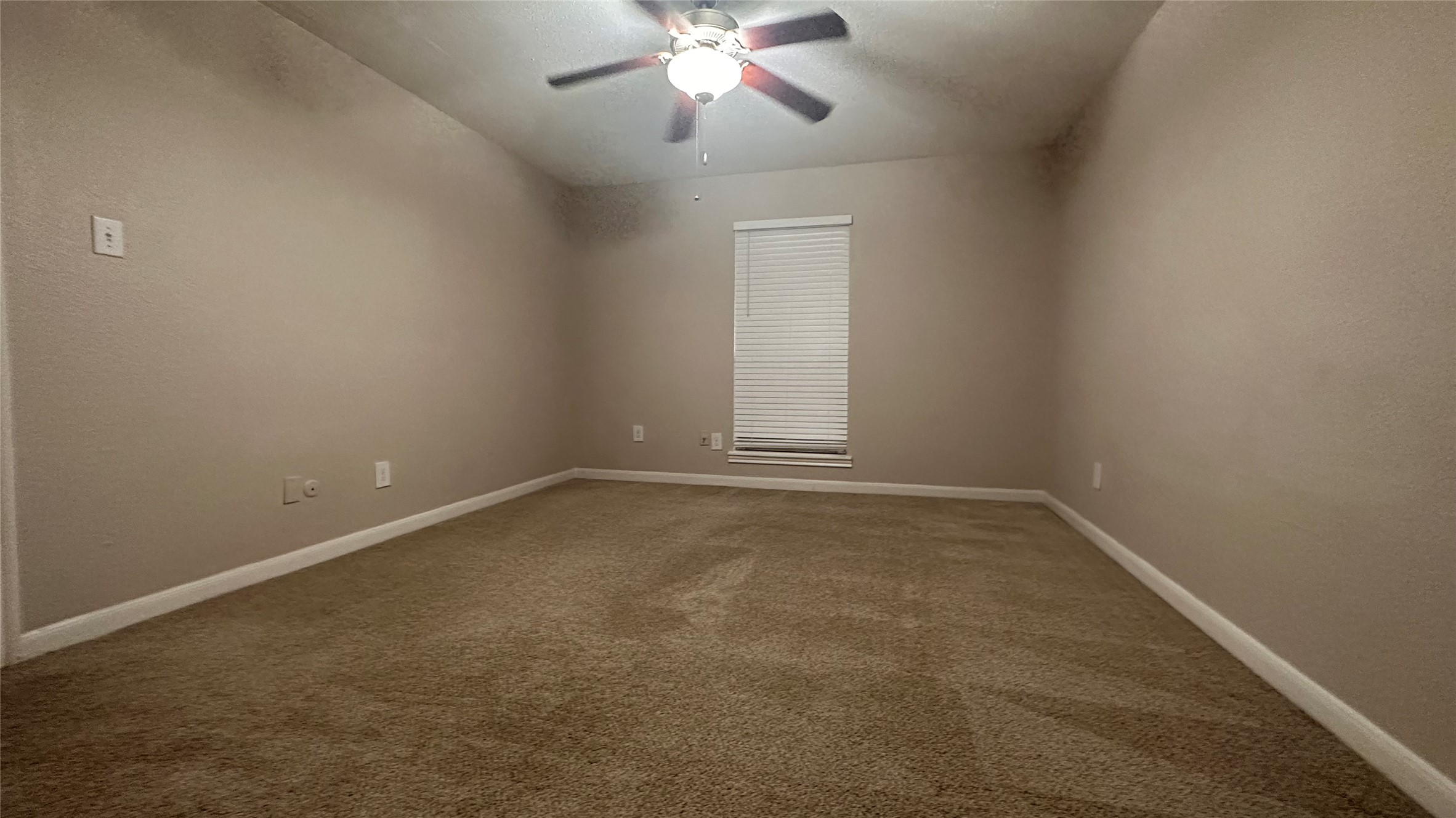 7315 Brompton Street, Unit 303B Houston, TX 77025 - Photo 13 of 14 an empty room with a chandelier fan and windows
