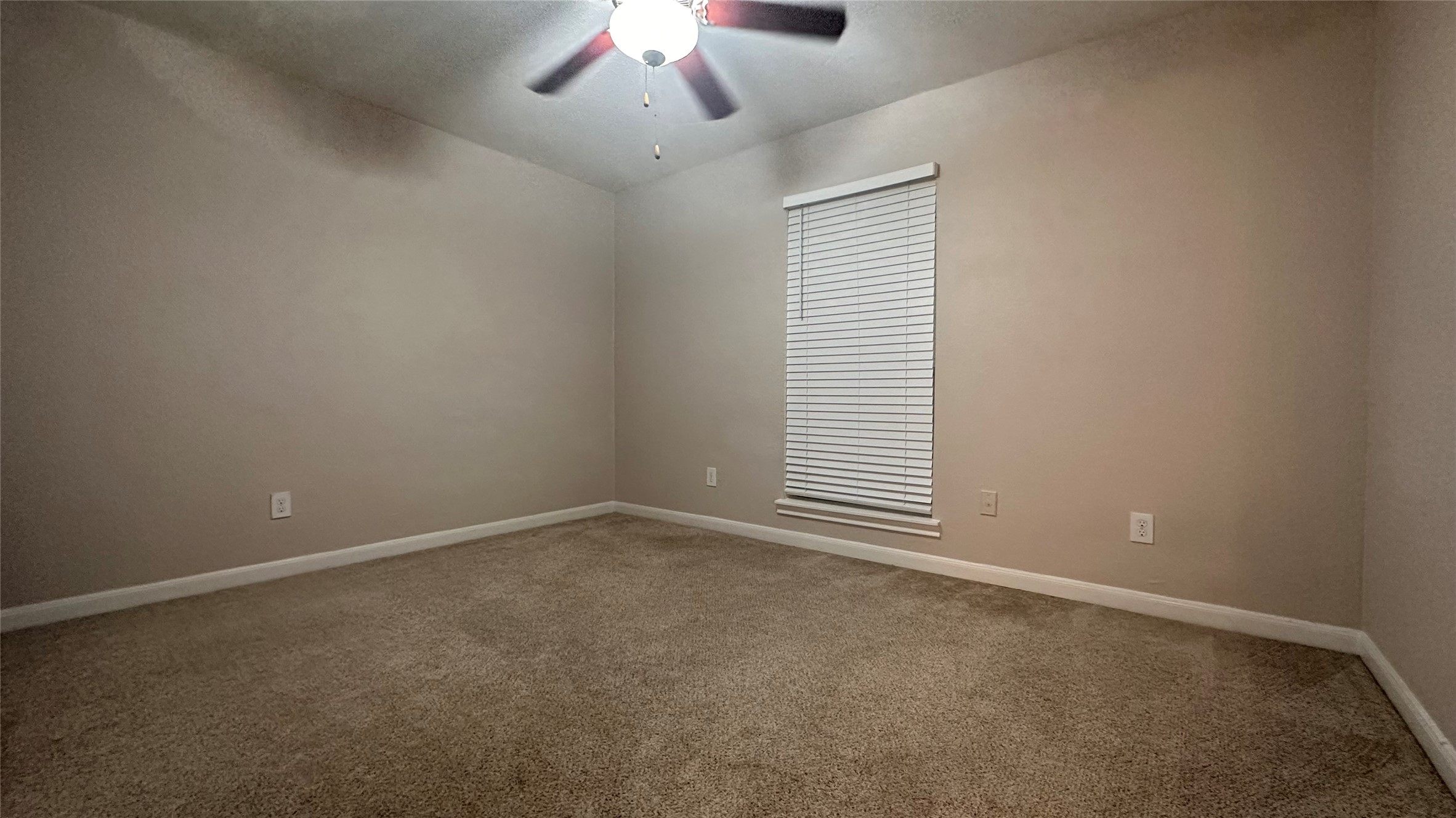 7315 Brompton Street, Unit 303B Houston, TX 77025 - Photo 6 of 14 an empty room with a chandelier fan and windows