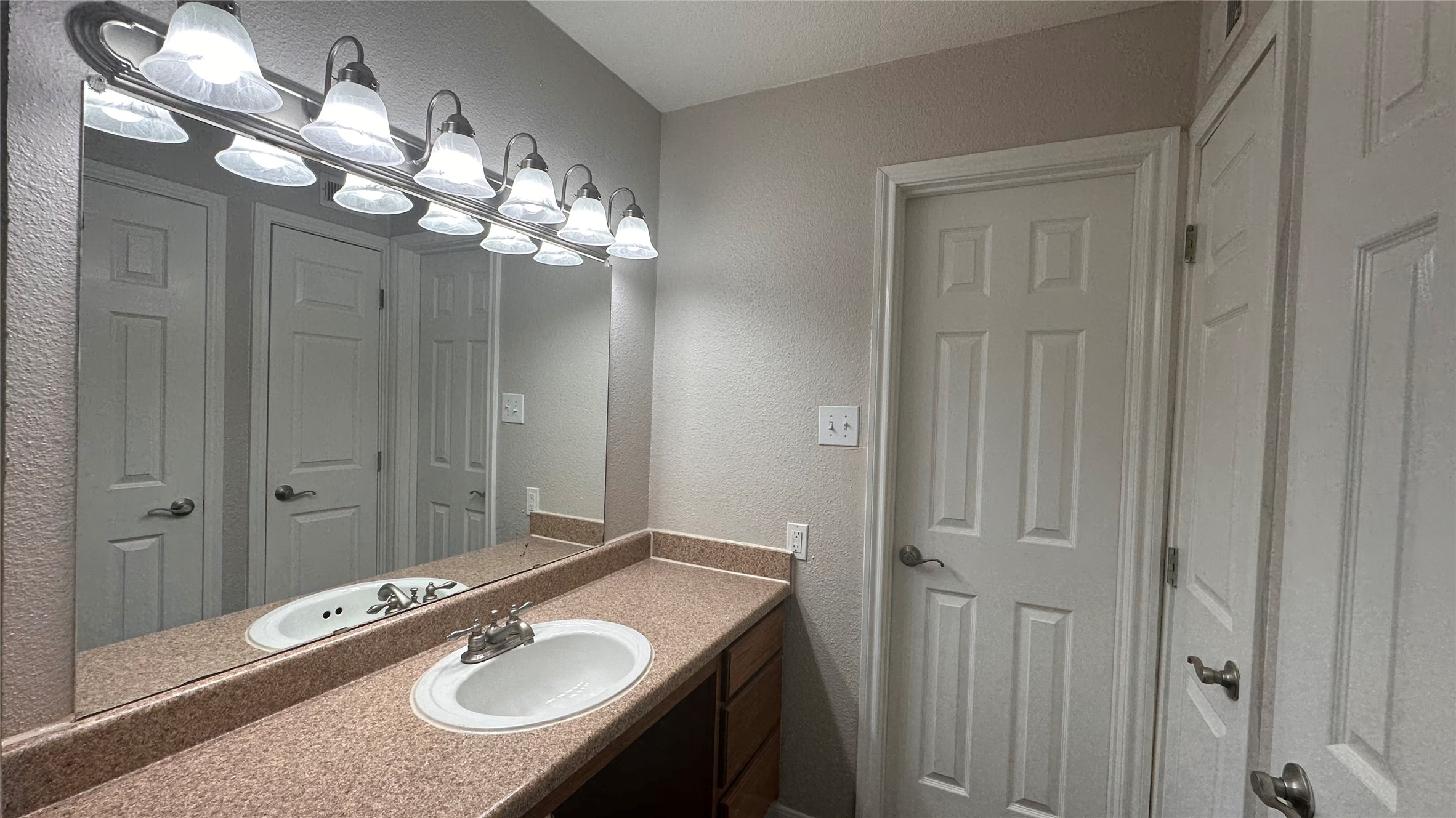 7315 Brompton Street, Unit 303B Houston, TX 77025 - Photo 9 of 14 a bathroom with a granite countertop sink a large mirror and a shower