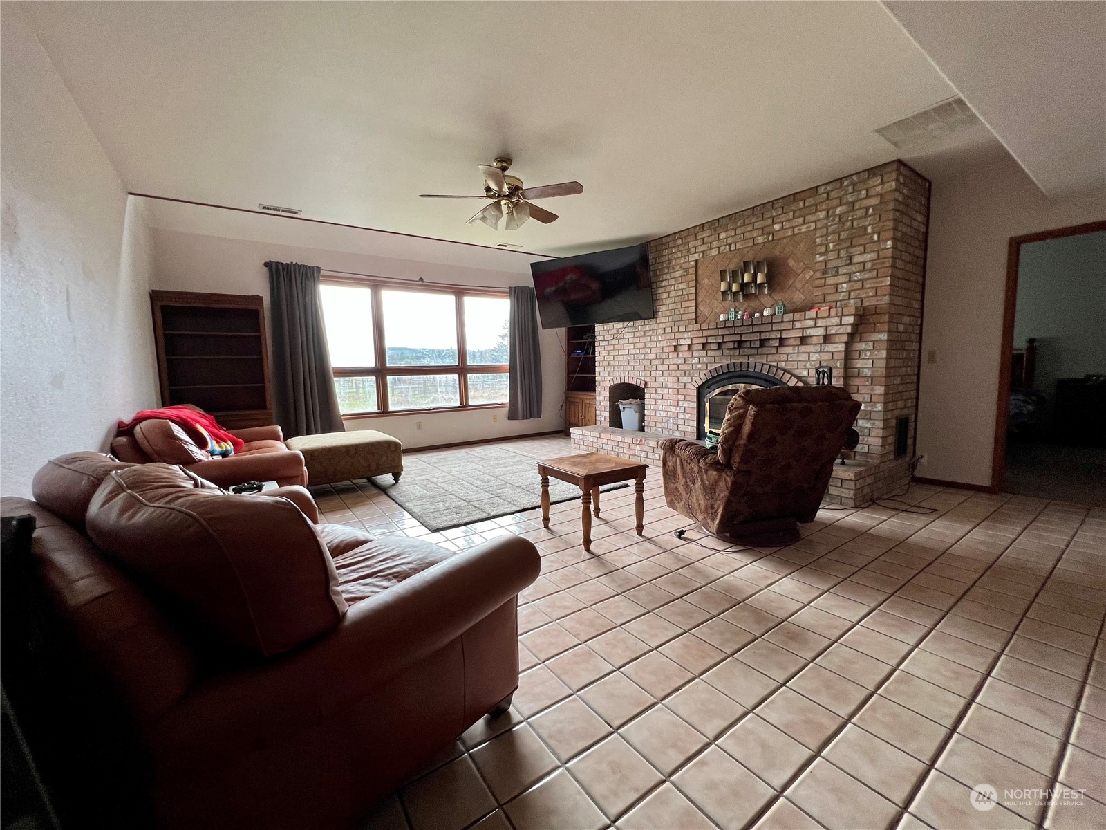 32 889 Elma, WA 98541 - Photo 15 of 29 a living room with furniture a fireplace and a chandelier