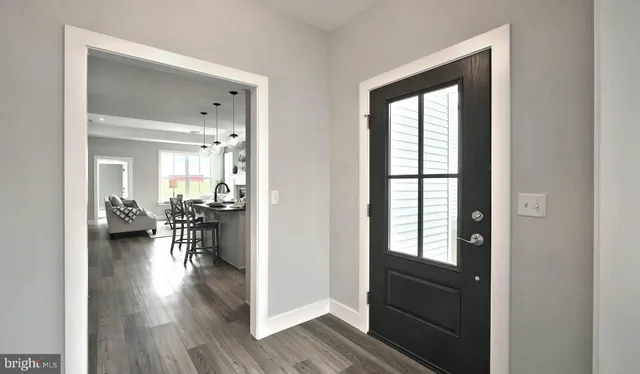 a hallway with a dining table wooden floor and a large window