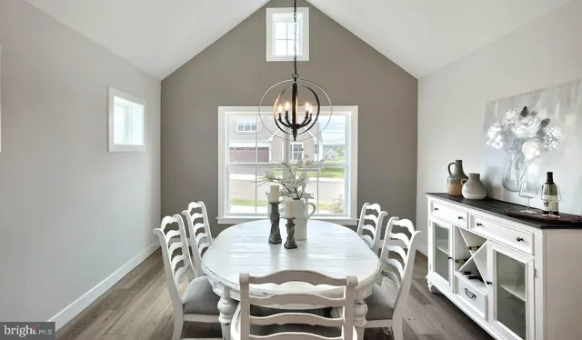 a dining room with furniture a chandelier and wooden floor