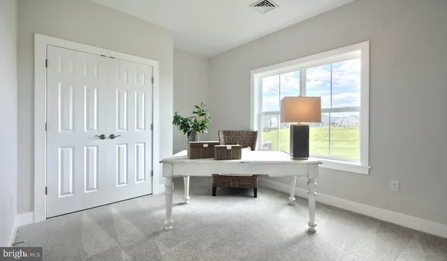 a view of a workspace with furniture and a window