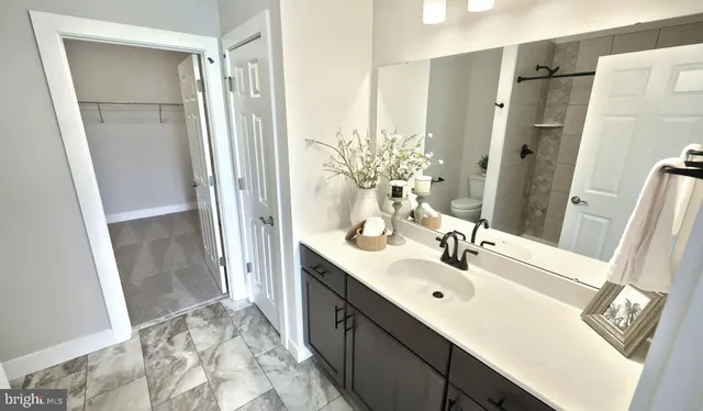 a spacious bathroom with a double vanity sink a mirror and a shower