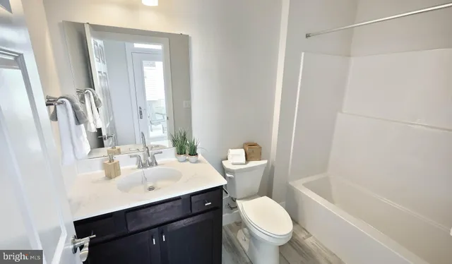 a bathroom with a sink toilet vanity and shower