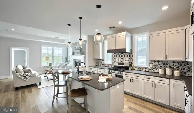 a kitchen with a sink stove and chairs