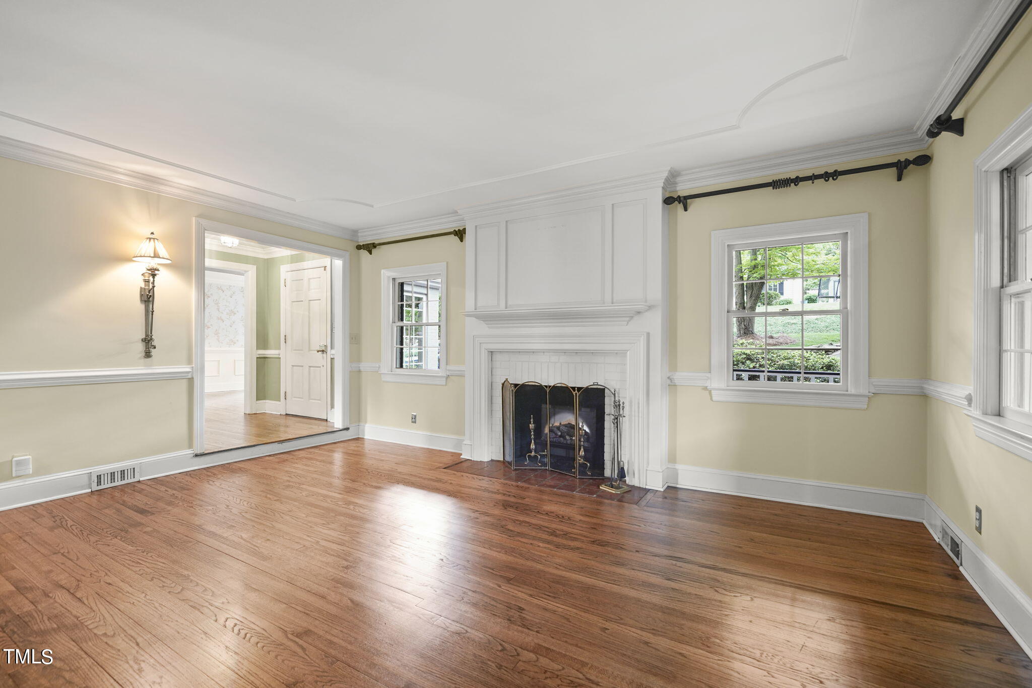 3100 Eton Road Raleigh, NC 27608 - Photo 10 of 45 an empty room with wooden floor fireplace and windows