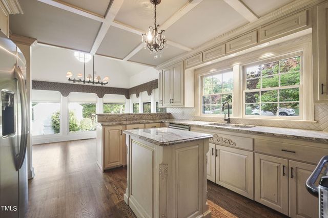 an empty room with wooden floor fireplace and windows