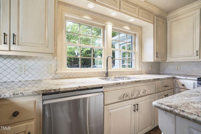 a kitchen with stainless steel appliances granite countertop a stove and a large window