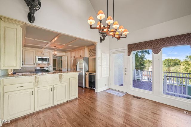a view of a dining room with furniture large windows wooden floor and chandelier