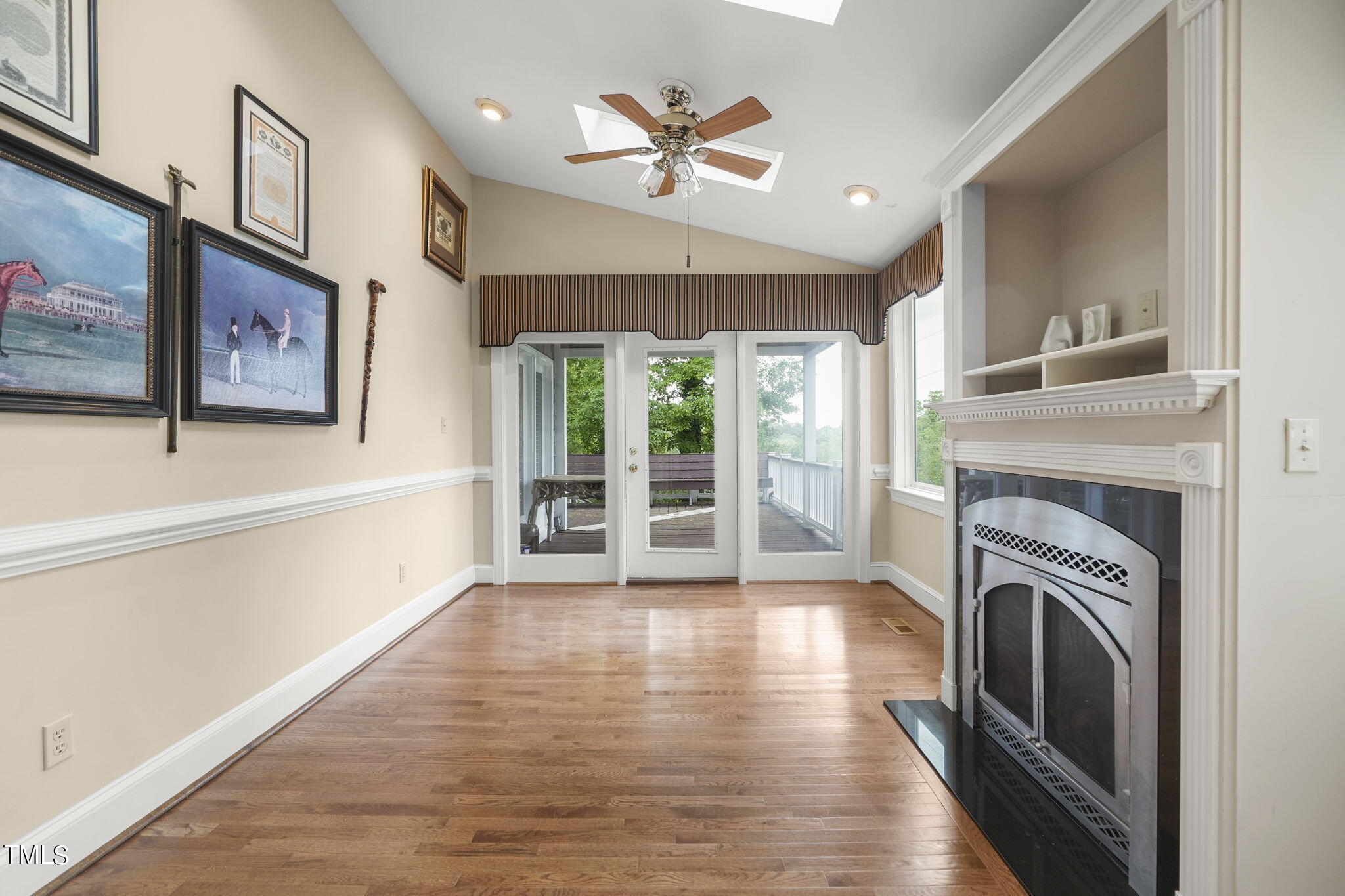 3100 Eton Road Raleigh, NC 27608 - Photo 26 of 45 a view of a livingroom with a fireplace a ceiling fan and wooden floor