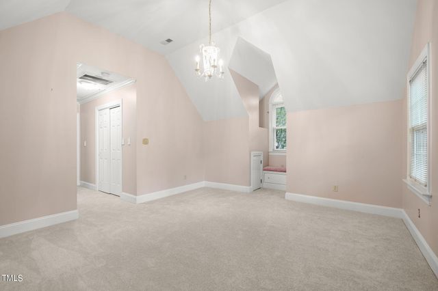 an empty room with windows and chandelier fan