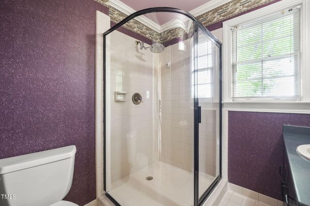 a bathroom with a glass shower door and a toilet