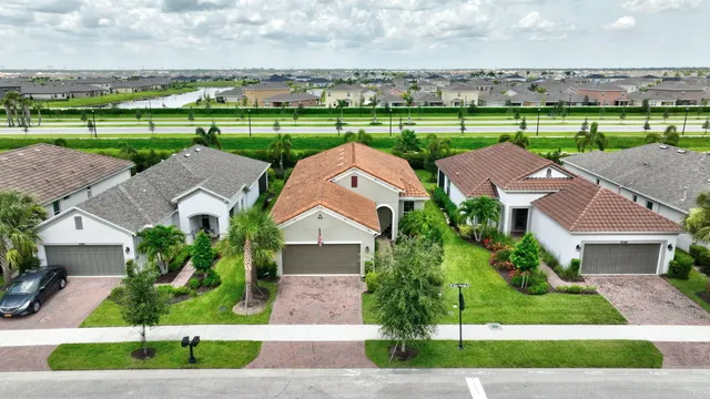 an aerial view of a house with a yard and lake view