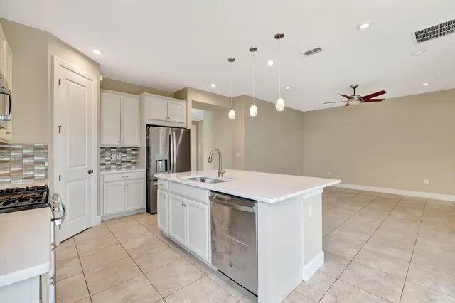 a kitchen with stainless steel appliances granite countertop a sink a stove and a microwave