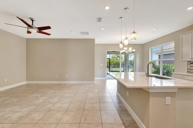 an open kitchen with granite countertop a sink and a large window