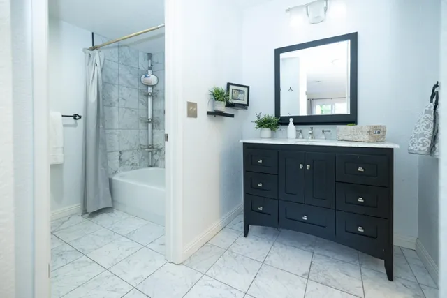 a bathroom with a tub a sink and mirror