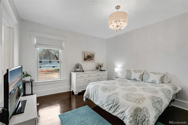 a bedroom with a bed and a chandelier