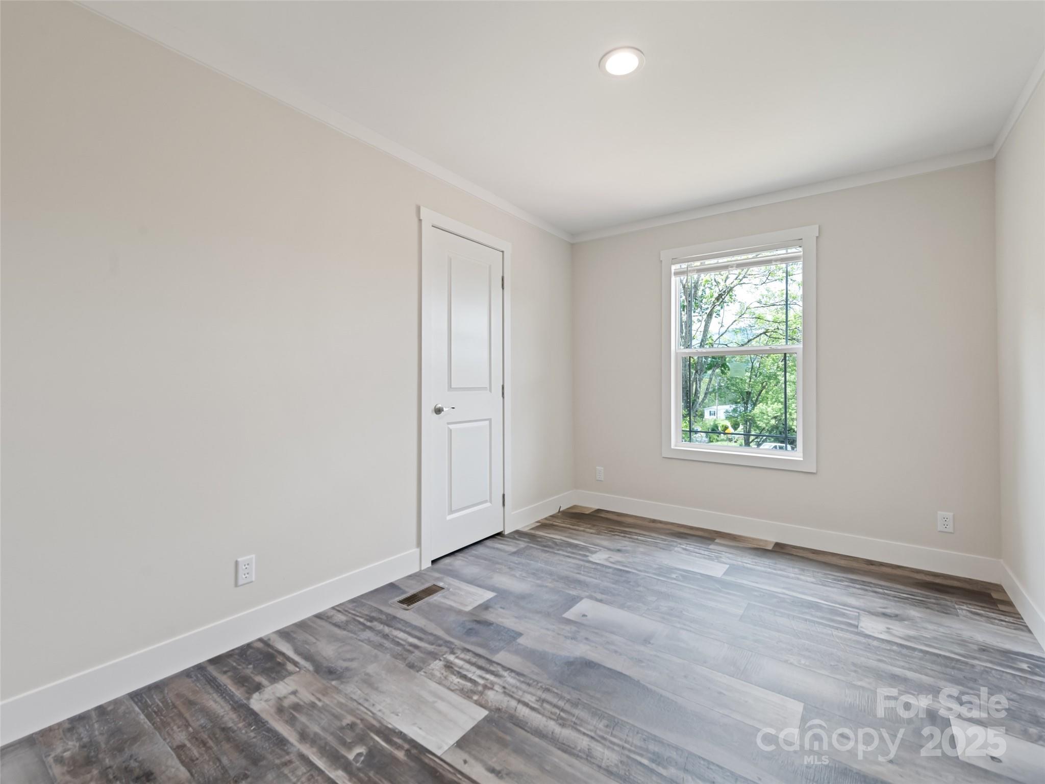 255 Thompson Cv Road Clyde, NC 28721 - Photo 19 of 24 an empty room with wooden floor and windows