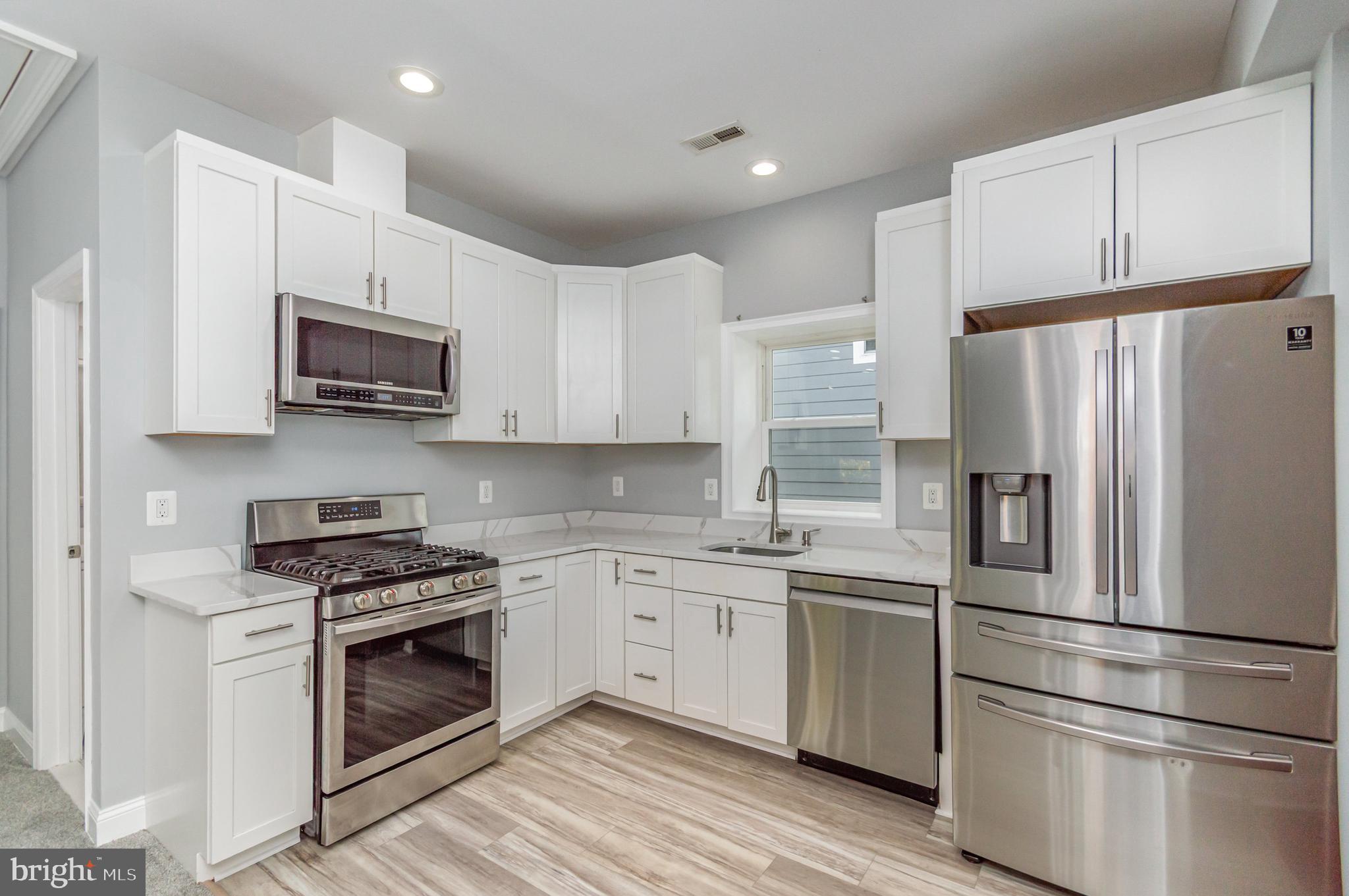 3110 Perry Street, Unit B Mount Rainier, MD 20712 - Photo 9 of 24 a kitchen with stainless steel appliances a refrigerator sink and microwave