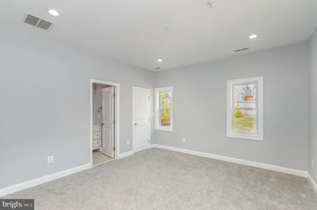a large kitchen with white cabinets and stainless steel appliances