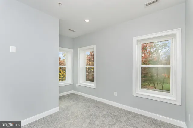 an empty room with windows and closet