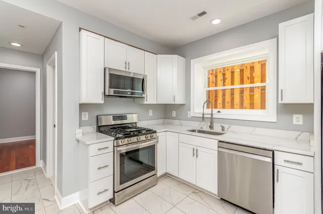 a view of a kitchen with refrigerator and windows