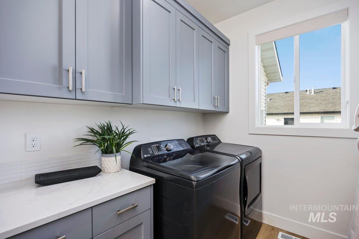 1046 Northridge Way Kimberly, ID 83341 - Photo 10 of 24 Laundry area featuring separate washer and dryer, cabinet space, and wood finished floors