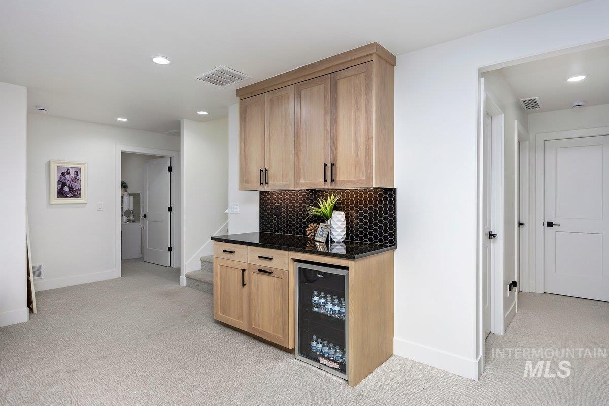 1046 Northridge Way Kimberly, ID 83341 - Photo 13 of 24 Bar area with recessed lighting, light colored carpet, beverage cooler, dark stone countertops, and light wood finish cabinetry