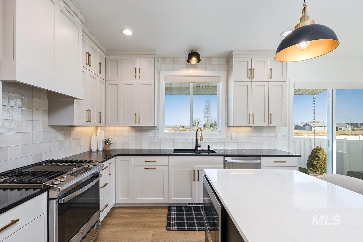 1046 Northridge Way Kimberly, ID 83341 - Photo 5 of 24 Dual tone kitchen with stainless steel appliances, dark stone countertops, light wood finished floors, and dual tone cabinets