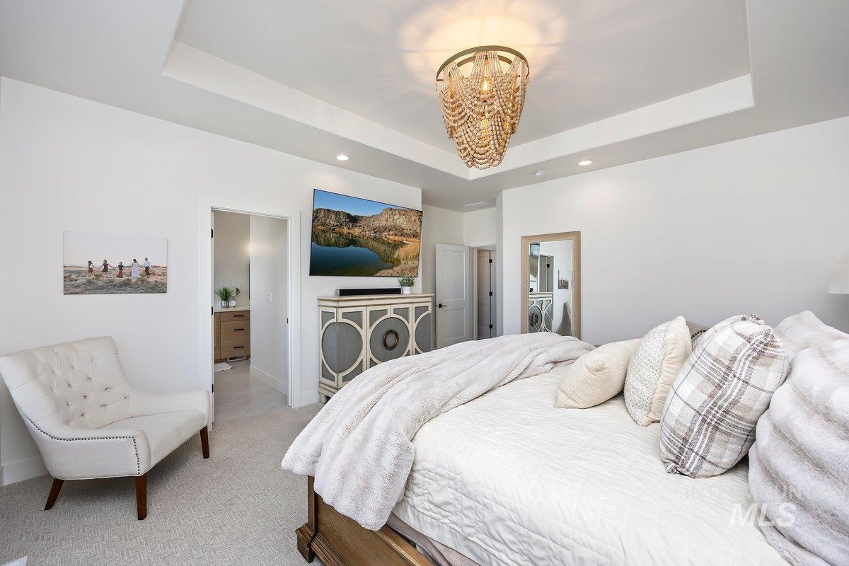 1046 Northridge Way Kimberly, ID 83341 - Photo 6 of 24 Bedroom featuring ensuite bathroom, carpet floors, a chandelier, and a tray ceiling