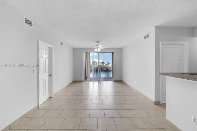 a view of a hallway with wooden floor and a living room