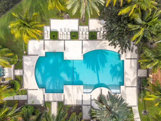 a view of a swimming pool with a garden and trees