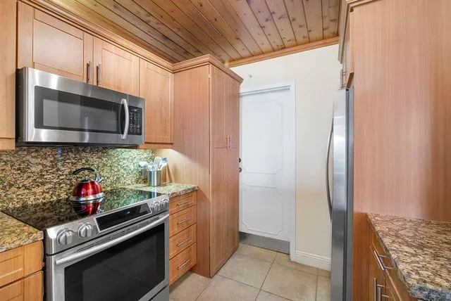 a kitchen with stainless steel appliances granite countertop a refrigerator and a stove